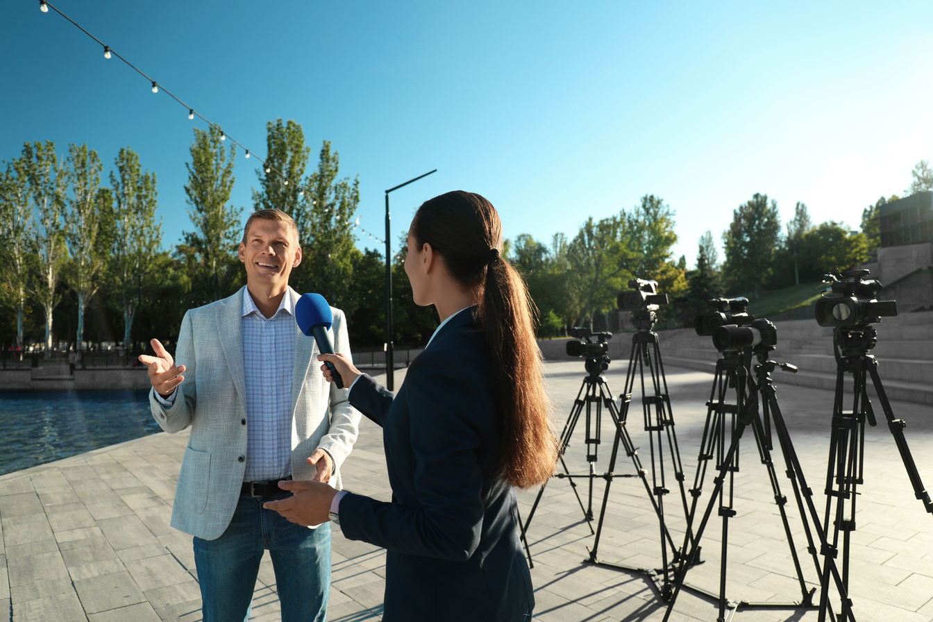 Young Journalist Interviewing Businessman on City Street